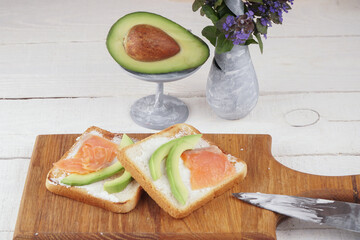 Toast with avocado and red fish. An exquisite breakfast of toast and flowers