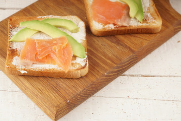 Toast with avocado and red fish. An exquisite breakfast of toast and flowers