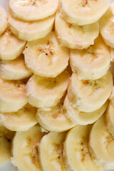Sliced bananas on a white plate. Delicious and juicy fruits. Breakfast on a plate.