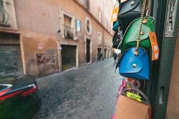 A colorful array of purses hang elegantly on a building, swaying gently in the breeze, creating a...