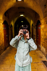 woman photographer with a camera takes pictures outdoors. A young female photographer aims the lens and enjoys the process of shooting. travel to Arab countries.