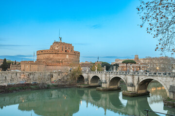 A majestic bridge stretches over a serene river, leading towards a ancient castle looming in the...
