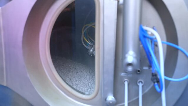 auto coating process. tablets in an auto coater. automatic medicine tablet making machine. Production line at a pharmaceutical factory. close up machine medical tablets rotating in an autocoater