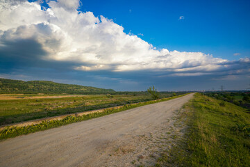 Fototapeta na wymiar unpaved road with blue sky with clouds.