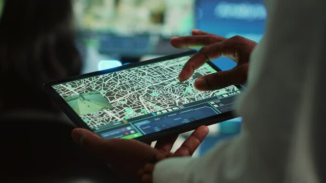 Manager tracking a delivery car by using satellite map for navigating around the city, monitoring orders via surveillance footage and CCTV system. Locating coordinates for shipping route. Camera A.