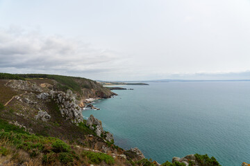 Fototapeta premium Les imposantes falaises encadrent la baie de Douarnenez, offrant un panorama saisissant de la côte bretonne, un spectacle naturel à couper le souffle.