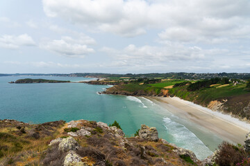 Fototapeta premium Depuis les hauteurs des falaises, un panorama grandiose s'offre à vous : la majestueuse mer d'Iroise s'étend à perte de vue, encadrée par la magnifique grande plage du Poul et l'île de l'Aber, une scè