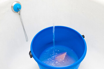 water is poured into a bucket with a rag