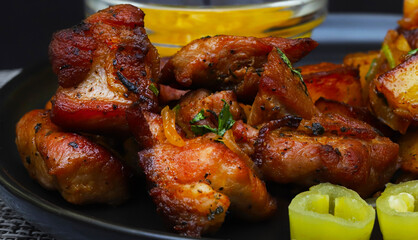 Juicy pieces of fried pork with onions and herbs. Close-up