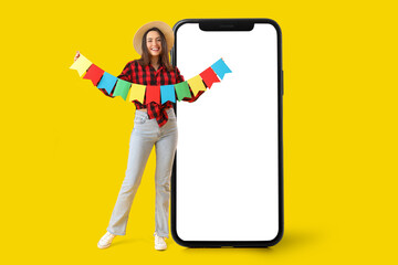 Young woman with flags on yellow background. Festa Junina (June Festival) celebration