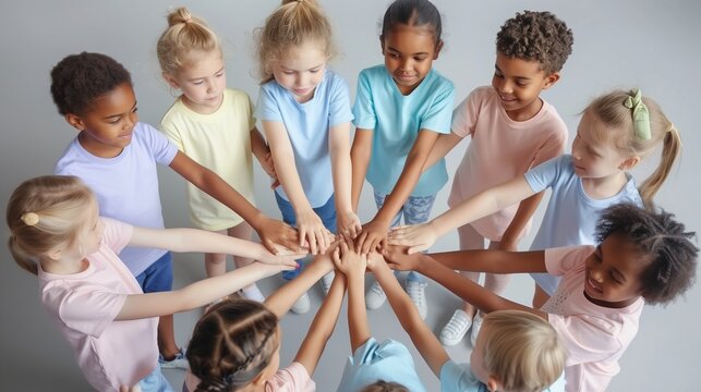 Children in a circle, each wearing different pastel-colored t-shirts, holding hands in unity against child labor
