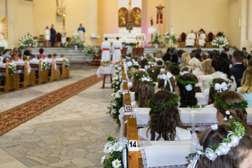 First Holy Communion holiday into a Christian church decorated with white flowers and ribbons