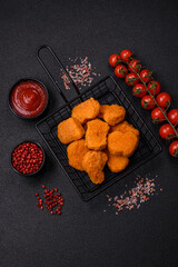 Delicious fresh crispy chicken nuggets on a dark concrete background