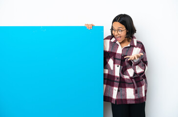 Young mixed race woman with a big blue placard isolated on white background with surprise facial...