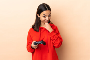 Young brunette mixed race woman playing with a video game controller over isolated background...