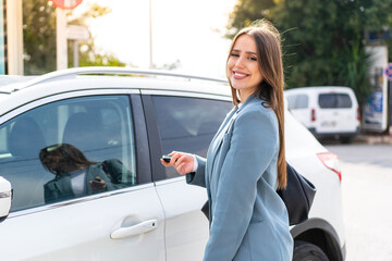 Young pretty woman holding car keys at outdoors