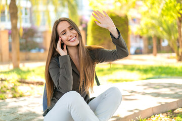Young woman at outdoors saluting