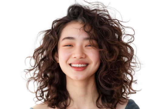 Young woman with long, curly hair smiling isolated on transparent background. She is wearing a white shirt and has a happy expression on her face .