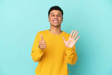 Young African American man isolated on blue background counting six with fingers