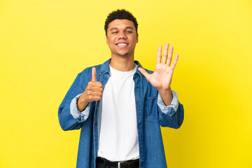 Young African American man isolated on yellow background counting six with fingers