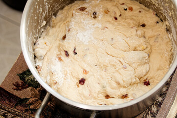 Kneaded dough with raisins in a pot, domestic kitchen. Preparation for Easter cake. Close up view....