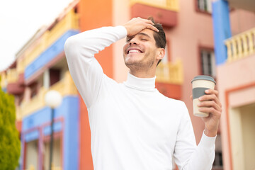Young caucasian man holding a take away coffee at outdoors has realized something and intending the solution - obrazy, fototapety, plakaty