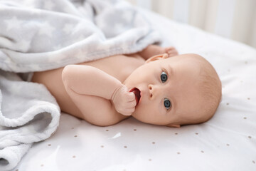Cute little baby lying in crib at home
