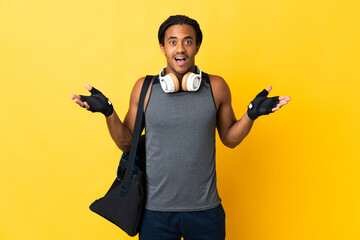 Young sport African American man with braids with bag isolated on yellow background with shocked...