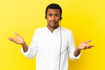 African American Telemarketer man working with a headset over isolated yellow background having...