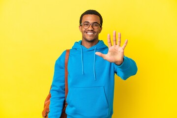 African American student man over isolated yellow background counting five with fingers
