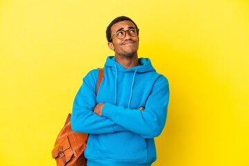 African American student man over isolated yellow background looking up while smiling