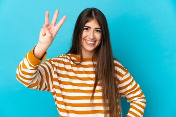 Young caucasian woman isolated on blue background happy and counting three with fingers