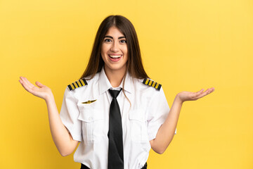 Airplane pilot isolated on yellow background with shocked facial expression
