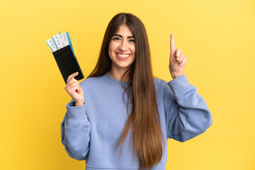 Young caucasian woman holding a passport isolated on yellow background pointing up a great idea