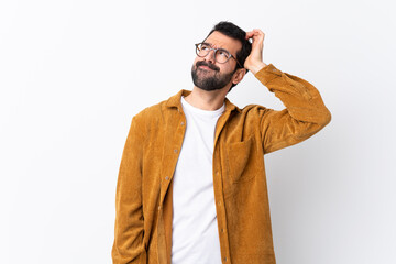 Caucasian handsome man with beard wearing a corduroy jacket over isolated white background having...