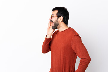 Caucasian handsome man with beard over isolated white background shouting with mouth wide open to the lateral