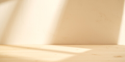 Empty table on sand color background with natural shadows on the wall. Mock up for branding products, presentation, food and health care.	