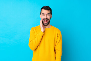 Young caucasian man over isolated blue background with surprise and shocked facial expression