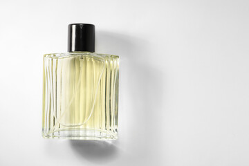 Luxury men`s perfume in bottle on white background, top view. Space for text