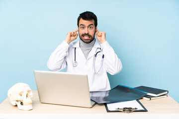 Professional traumatologist in workplace frustrated and covering ears