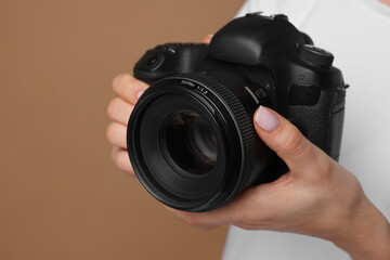 Photographer with camera on brown background, closeup