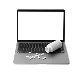 Laptop, overturned bottle and pills isolated on white