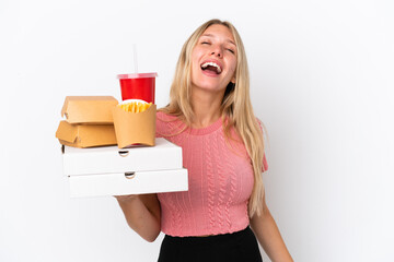 Young caucasian woman holding fat food isolated on blue background laughing
