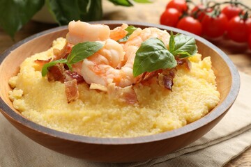 Fresh tasty shrimps, bacon, grits and basil in bowl on table, closeup