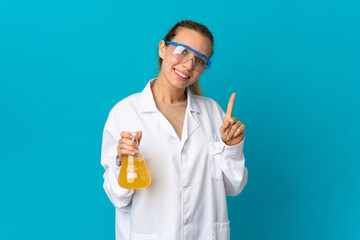 Young scientific woman isolated on blue background showing and lifting a finger in sign of the best