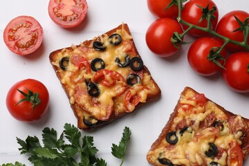 Tasty pizza toasts, fresh tomatoes and parsley on white tiled table, flat lay