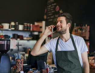 Man, barista and phone call for communication in coffee shop for hospitality, take away and bistro...
