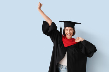 Happy female graduating student on blue background