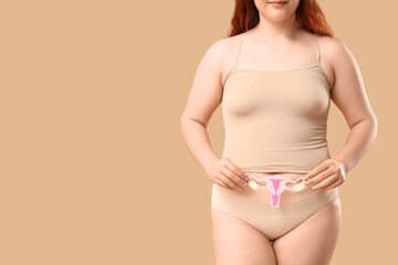Young woman in period panties holding paper uterus on beige background