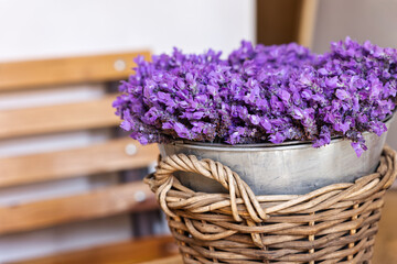 lavender fresh bunch of flowers in a bucked sited in a raffia basket on a bench